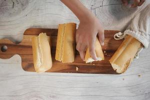 cortando pan de frente horneado en la mesa. foto