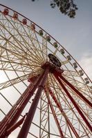 Round ferris wheel spins fast at colorful day