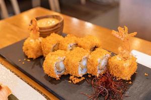 maki tempura, rollo de sushi de gambas o camarones fritos, en pizarra. estilo de comida de fusión tradicional japonesa, menú de restaurante. foto de primer plano con enfoque selectivo.