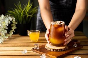 Glass of espresso with orange juice on wooden table and copy space, Summer Cocktail, Cold brew coffee or black tea