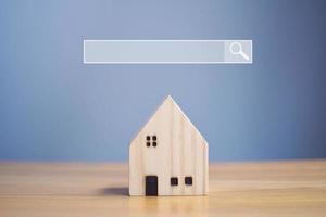 Internet search bar and house models to find real estate. photo