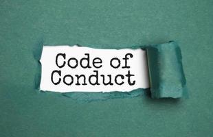 The text Code of conduct appearing behind torn brown paper photo