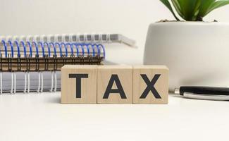 Close-up Of Bill With Calculator And Tax Text On Wooden Blocks photo