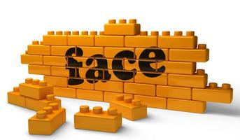 face word on yellow brick wall photo