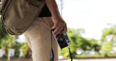 Close up of Man hand holding camera while walking at street. Smiling male and female using mobile phone navigating map application. Holiday, travel and hobby concept. video