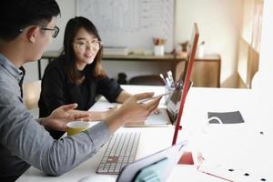 An investment expert points a pen at a computer monitor to analyze the stock market to teach you how to make a profit. photo