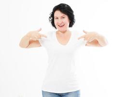 Portrait of smiling middle age caucasian woman wearing t shirt pointing at hemself by finger isolated on white template and blank background. photo