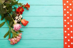 Frame of flowers and towels in polka dots on blue wooden background. Top view and selective focus. Copy space photo