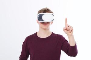 Young Man wearing virtual reality goggles and toch space by finger isolated on white background. VR concept and copy space. Selective focus. Blank template Shirt. photo