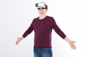 Young man wearing virtual reality goggles isolated on white background. Digital VR glasses for 360 game. Template and blank shirt. Copy space and mock up photo