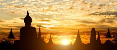 silueta de buda en el fondo de la puesta de sol del templo dorado. atracción de viajes en tailandia. foto