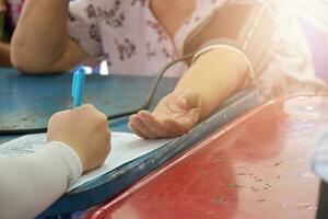 primer plano del brazo del paciente durante la medición de la presión arterial en la consulta médica. unidad medica movil foto