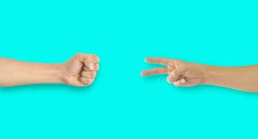 Two hands playing rock-paper-scissors on blue background photo