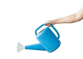 Hand holding a blue watering can, Isolated on white background with clipping path. Concept of gardening. photo