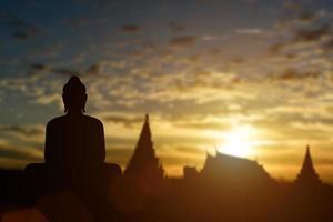 silueta de buda en el fondo de la puesta de sol del templo dorado. atracción de viajes en tailandia. foto