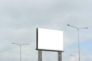 cartelera en blanco sobre fondo de cielo azul para afiches publicitarios al aire libre. foto