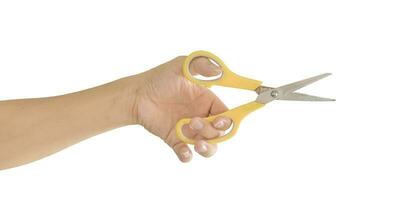 hand holding yellow scissors isolated on white background. Object with clipping path. photo