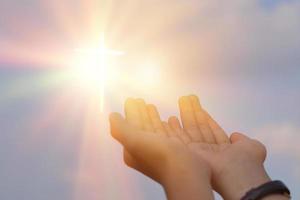 Hands open palm up worship over sunrise background. Catholic praying for blessing from god. photo