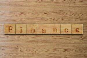 finance word letters on wood block. message text on wooden table for backdrop design. photo