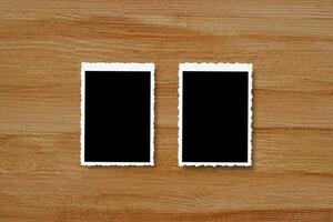 Top view of blank photo frames on wooden table background.