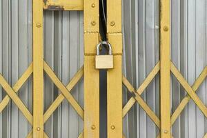 Locked padlock on gold metal door photo