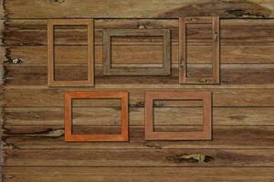 Vintage photo frames on wood wall for interior or background.