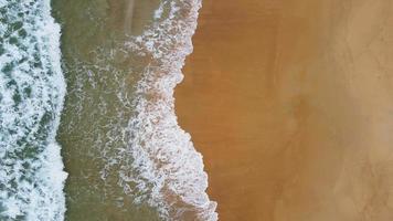 vista aérea da praia de areia branca e textura da superfície da água. ondas espumosas com céu. bela praia tropical. incrível litoral arenoso com ondas do mar branco. conceito de natureza, marinha e verão. video