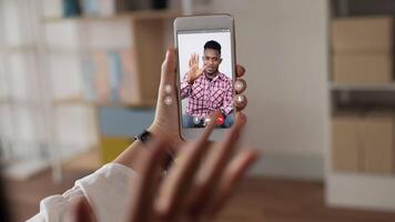 Close up hand of Happy female holding mobile phone and skype chatting with black people man. Young asian woman having video call via smartphone talking to friend. Online internet and technology.