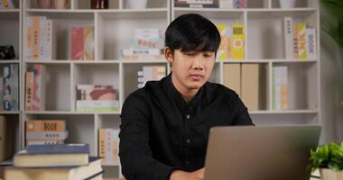 Sleepy asian businessman sits at workplace desk with a laptop working at home office. Tired employee man sleeping at workplace near laptop feel overworked concept. video