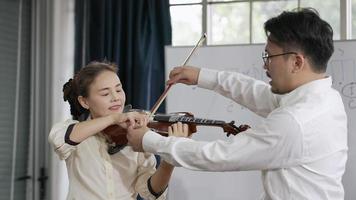 donna adulta che impara a suonare il violino in classe di musica