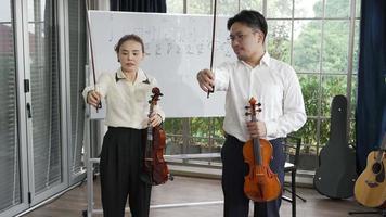 femme adulte apprenant à jouer du violon en classe de musique video