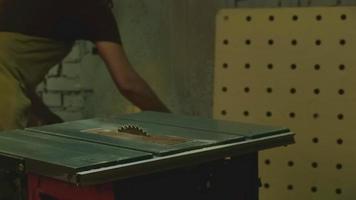 The master saws boards on a circular saw