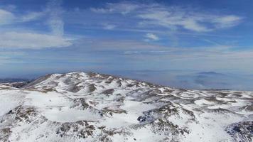 vinter på en bergsplatå. ängar täckta med snö, solig vinterdag. flygfoto av en bergstopp med en drönare. video