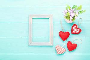 Romantic frame with copy space and accessories on blue wooden background. Top view photo