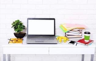 Education accessories on the table near brick wall. Empty computer screen with place for text. selective focus photo