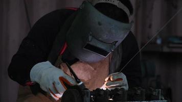 des hommes professionnels portant un masque de soudage et des gants travaillent dans un atelier à domicile avec soudage à l'arc et argon. video