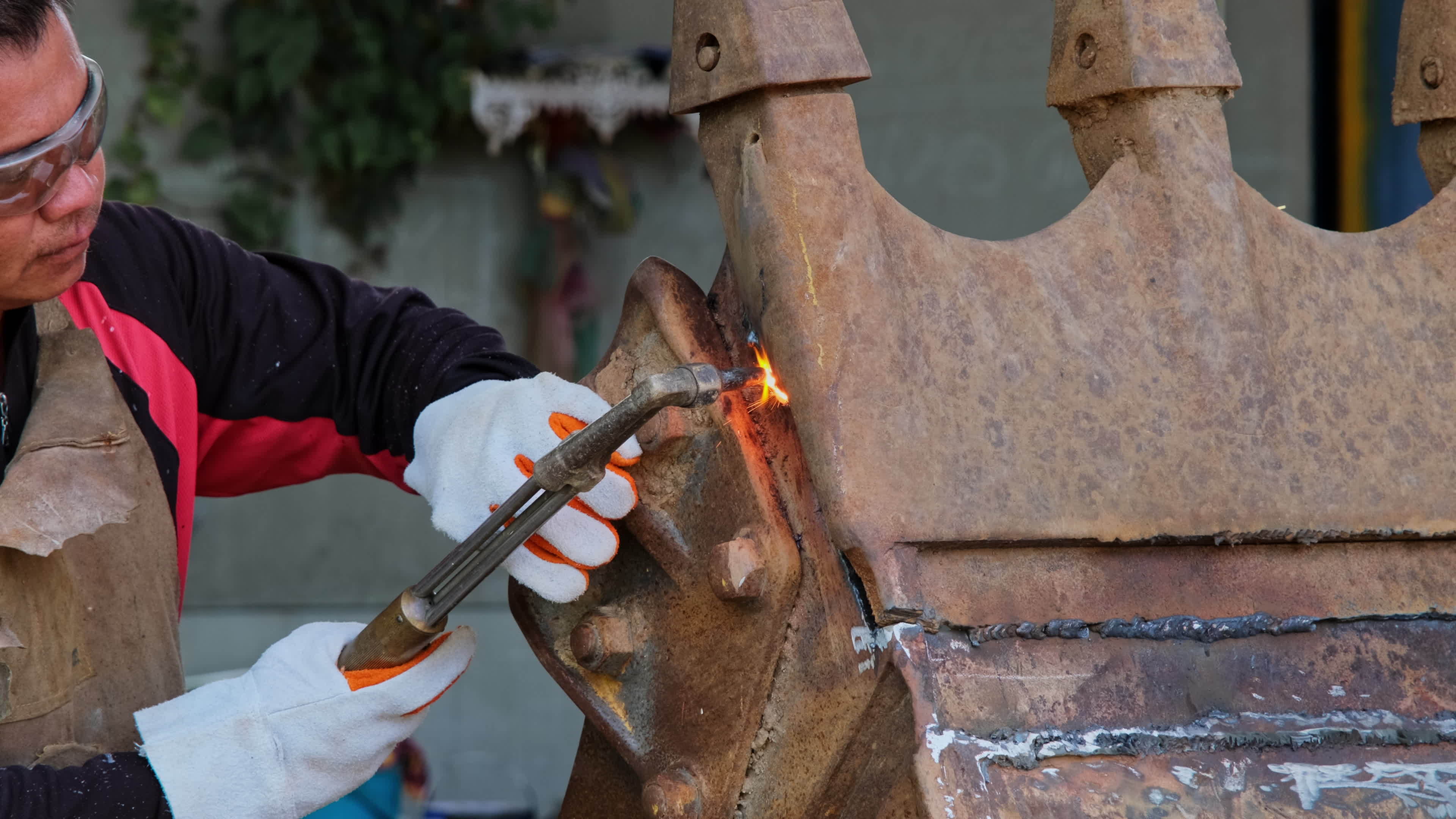 Worker cutting steel with a gas torch. Man cutting steel with propane