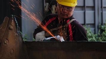 el hombre trabaja en el taller doméstico con amoladora angular, gafas y guantes de construcción. lijar metal hace chispas, primer plano video