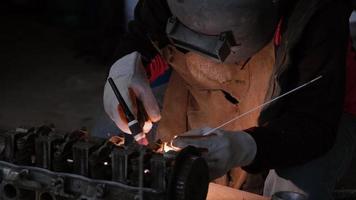 Professional men wearing welding mask and gloves work in home workshop with arc welding and argon. video