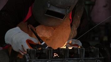 Professional men wearing welding mask and gloves work in home workshop with arc welding and argon. video