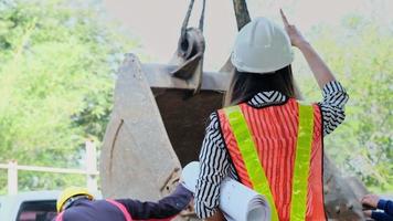 Female engineer looks at project blueprints and inspects work while standing on a construction site. video