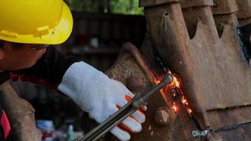 travailleur coupant de l'acier avec un chalumeau à gaz. homme coupant de l'acier avec du propane et de l'oxygène. processus qui utilisent des gaz combustibles et de l'oxygène pour souder et couper des métaux.
