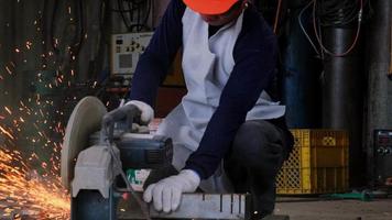 Professional men wearing goggles and construction gloves work in home workshop with angle grinder. Sanding metal makes sparks, closeup video