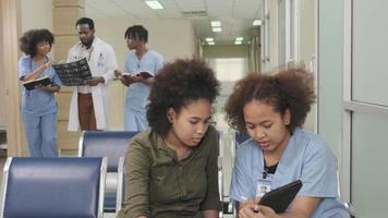 Interior atmosphere in working day times of the healthcare clinic, hospital's outpatient waiting area, groups of doctors and medical students talk and walk, discuss and consult patient examinations. video