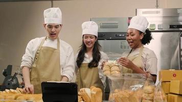 tres jóvenes socios de inicio de chefs, blogger de pequeñas empresas que transmiten en vivo a través de tecnología de aplicaciones móviles, promoción de ventas de panadería en línea, pan fresco, comida de pastelería y cocina comercial. video