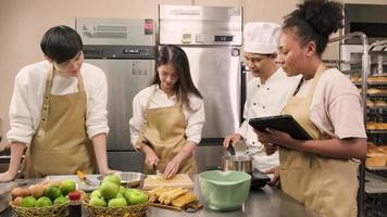 curso de culinária de hobby, chef masculino sênior em uniforme de cozinheiro ensina jovens estudantes de culinária a descascar e picar maçãs, ingredientes para alimentos de pastelaria, tortas de frutas na cozinha de aço inoxidável do restaurante.
