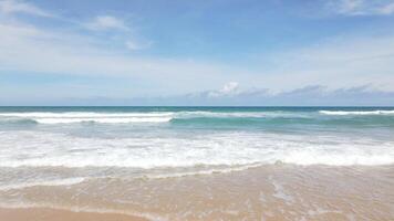 luftaufnahme von sandstrand und wasseroberflächenstruktur. Schaumige Wellen mit Himmel. Drohnenfliegen am wunderschönen tropischen Strand. erstaunliche Sandküste mit weißen Meereswellen. natur, seelandschaft und sommerkonzept. video