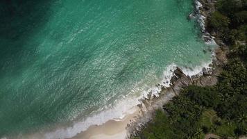 Aerial view of sand beach and water surface texture. Foamy waves with sky. Beautiful tropical beach. Amazing sandy coastline with white sea waves. Nature, seascape and summer concept. video