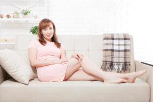 Attractive and beautiful middle aged woman sitting on sofa and relaxing at home. Menopause photo