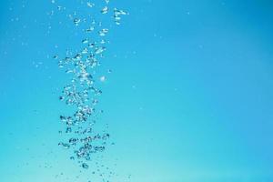 Abstract background image of bubbles in water. Clean water with water droplets and waves. Fresh water a glass with bubbles blue background. photo